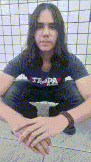 a young man wearing a trapa shirt sits on the floor