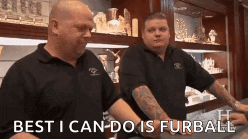 two men are standing next to each other in a store and one of them is holding another man 's arm .