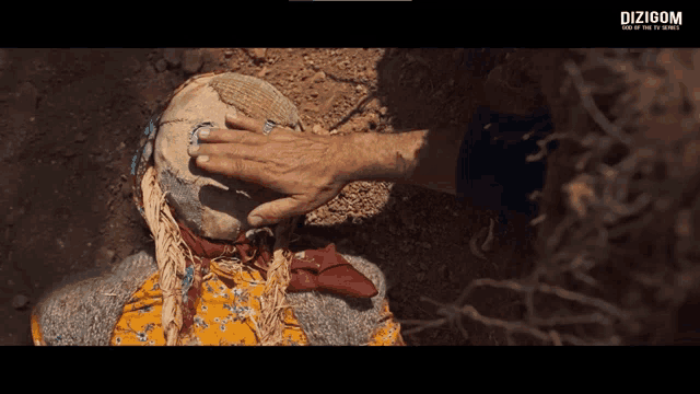 a person touching a scarecrow 's head with a dizigom logo in the corner