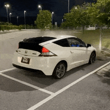 a white honda cr z is parked in a parking lot .