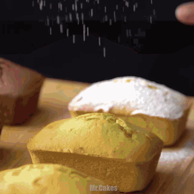 powdered sugar is being sprinkled on a few cupcakes with the words mr.cakes below