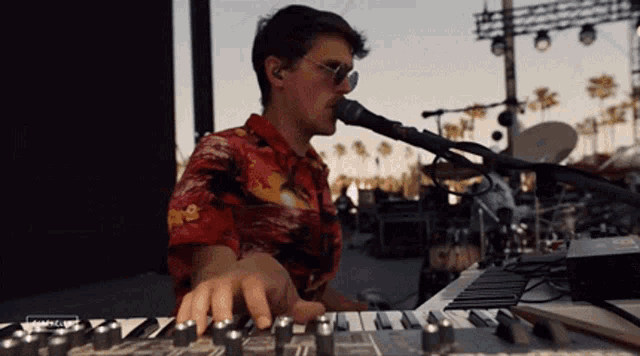 a man playing a keyboard and singing into a microphone