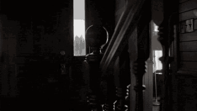a black and white photo of a staircase leading up to a doorway .