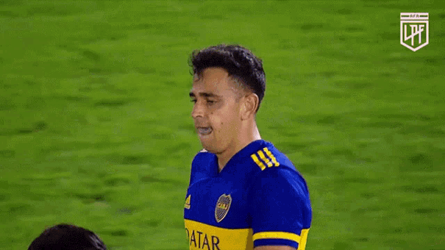 a soccer player wearing a blue and yellow qatar airways shirt