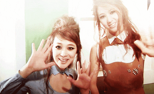 two women are posing for a picture and one is wearing a brown dress