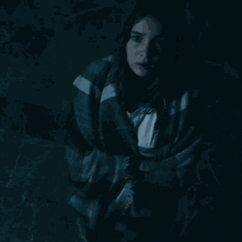 a woman is wrapped in a plaid blanket and the words holy shit are above her