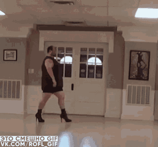 a man is doing a handstand in a room with a picture of a woman on the wall
