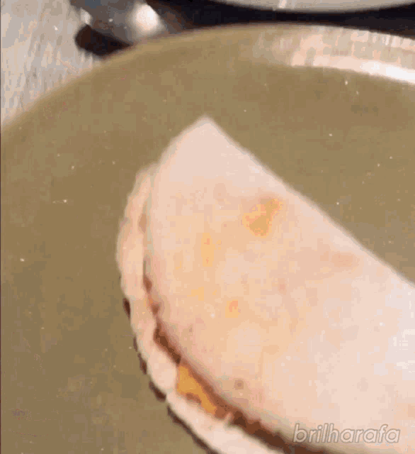 a close up of a sandwich on a plate with the words brilharafa written on the bottom