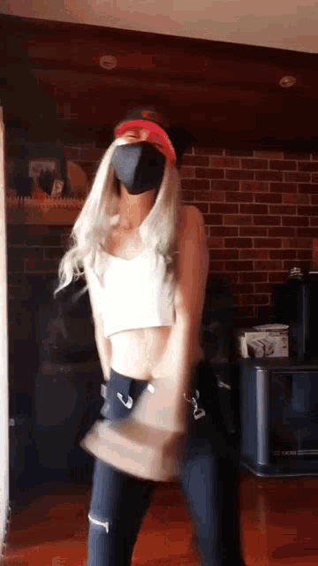 a woman wearing a mask and a hat is dancing