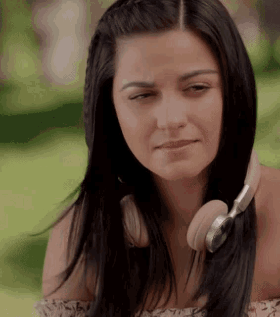 a woman wearing headphones is making a sad face