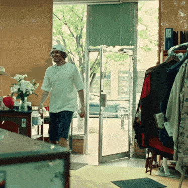 a man walking into a store with a sign on the door that says ' a ' on it