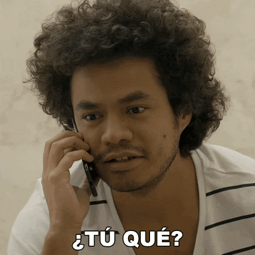 a man with curly hair is talking on a cell phone and has the words " tu que " above him