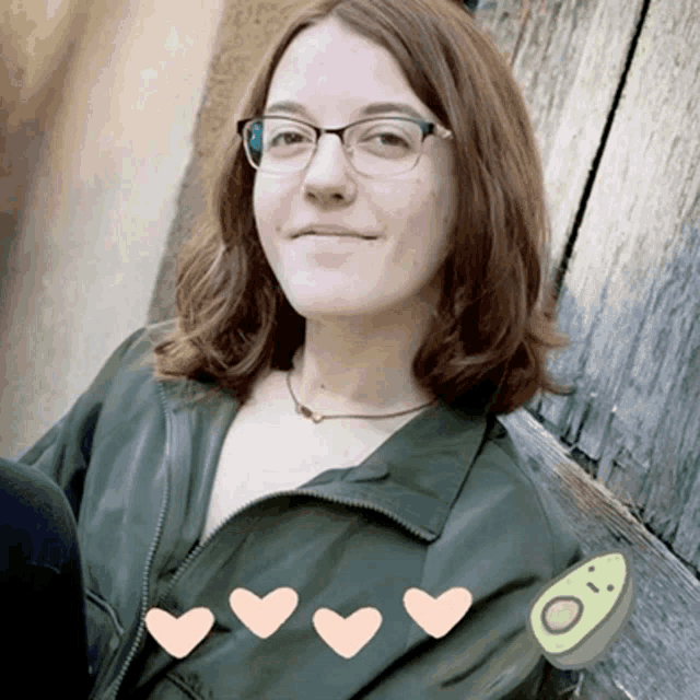 a woman wearing glasses and a green jacket with hearts on it