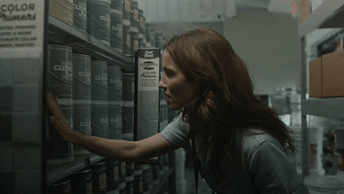 a woman reaches into a shelf of clens paint