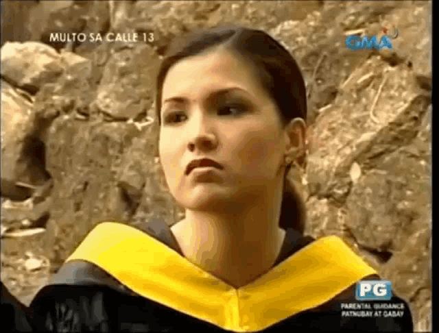 a woman in a graduation cap and gown is on a television screen .
