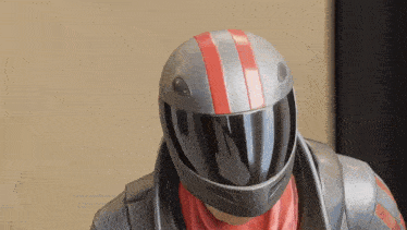a man wearing a motorcycle helmet with a red stripe