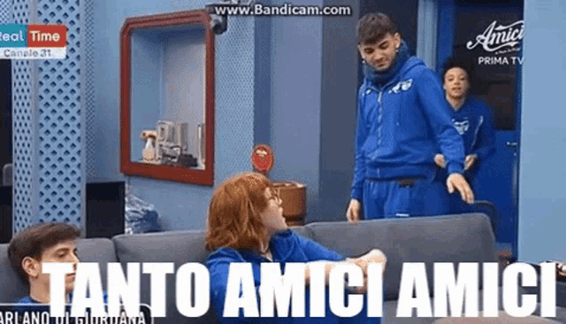 a group of people are sitting on a couch with the words " tanto amici amici " written on the bottom