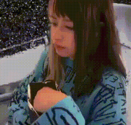 a young girl in a blue sweater is looking at a watch on her wrist .