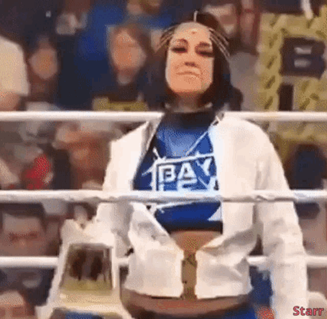 a woman in a wrestling ring wearing a shirt that says team