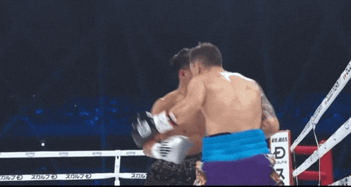 a man in a boxing ring with a referee and a rope that says ' sbc ' on it