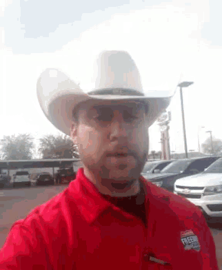 a man wearing a white cowboy hat and a red shirt with the word freeway on it