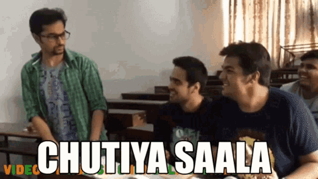 a group of young men are sitting around a table with chutiya saala written on the top