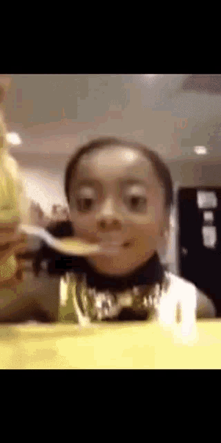 a young boy is eating a pancake with a fork and spoon .