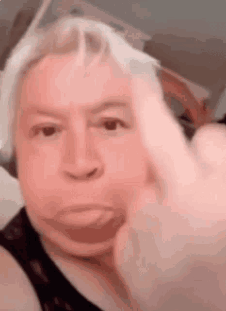a man is making a funny face and giving a middle finger .