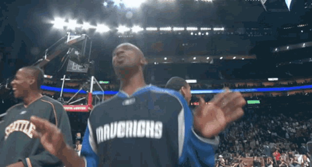 a man wearing a mavericks jersey stands on a basketball court