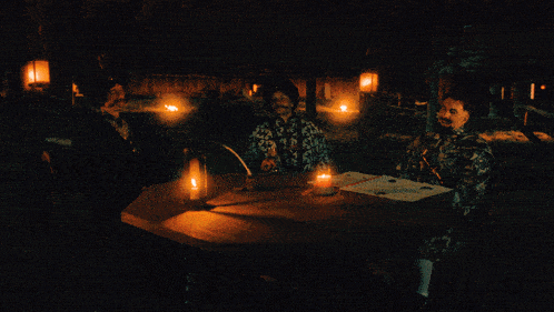 three men sit at a table with candles and the words what 's a clitoris