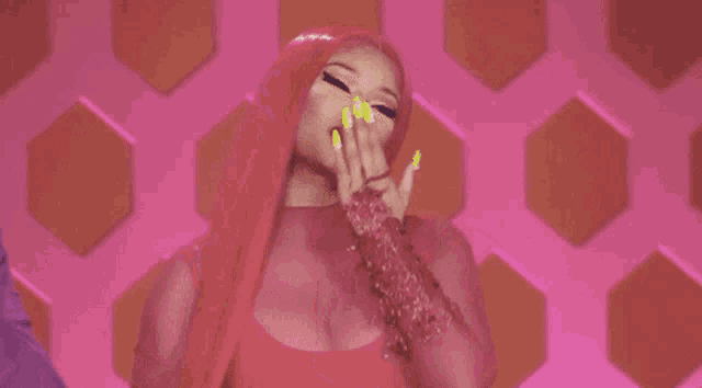 a woman with pink hair and neon yellow nails is making a face