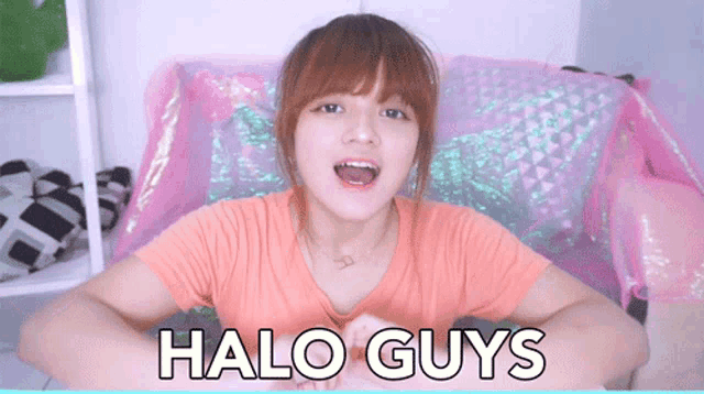 a girl sitting on a pink couch with the words halo guys written on her chest
