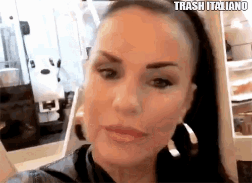 a woman wearing hoop earrings and a ponytail is looking at the camera .