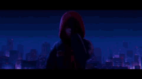spider-man is standing in front of a city at night .