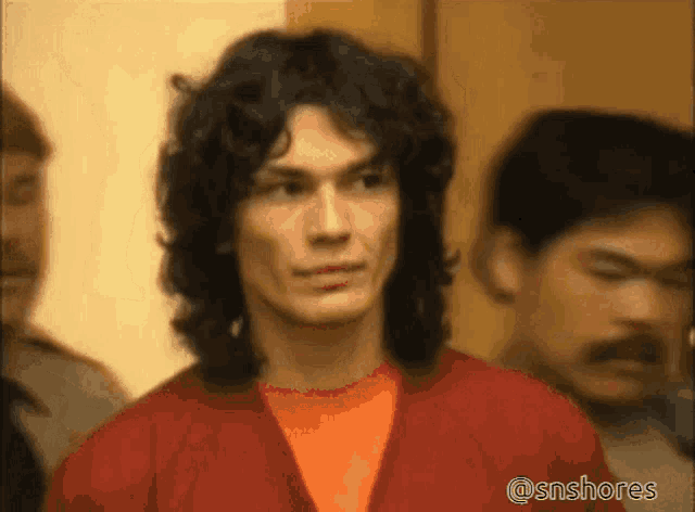 a man with long curly hair is standing in a crowd of people with the hashtag @snshores on the bottom