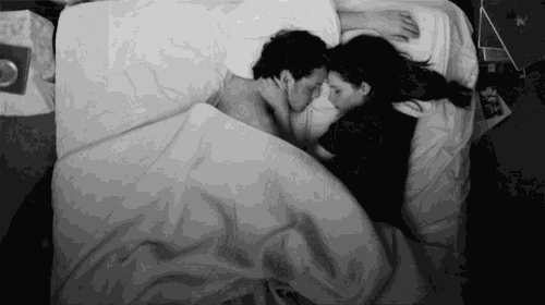 a black and white photo of a man and woman sleeping