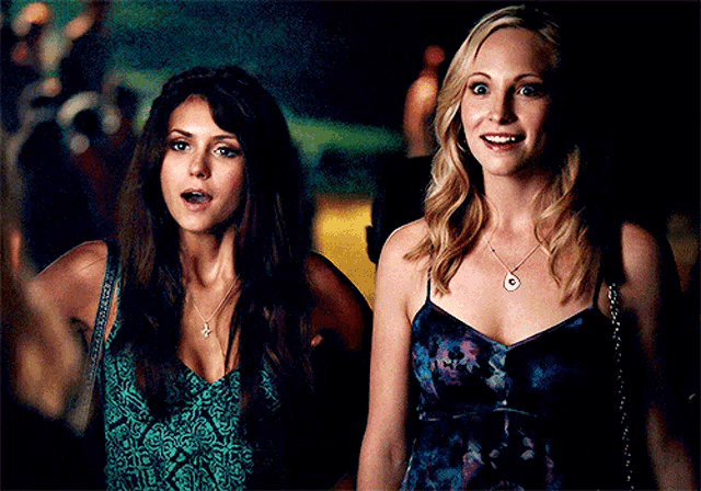 two women are standing next to each other and smiling