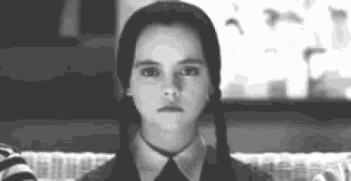 a black and white photo of a young girl in a suit and tie .