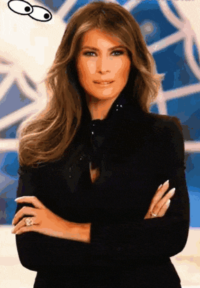 a woman with her arms crossed is wearing a black jacket and a ring