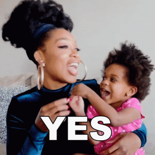 a woman is holding a baby in her arms and the baby is laughing and says yes