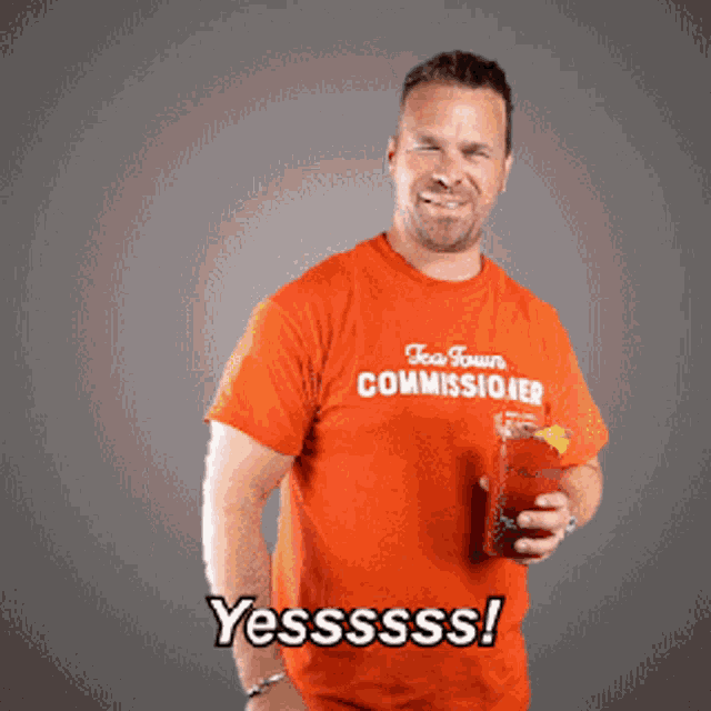 a man wearing an orange shirt that says tea town commissiver