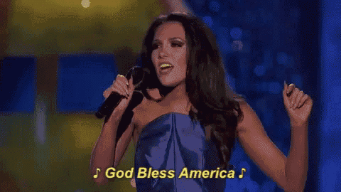 a woman singing into a microphone with the words god bless america written on the bottom