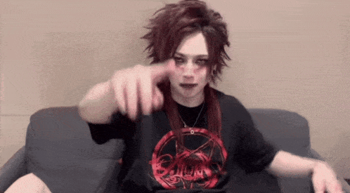 a person with red hair and a black shirt with a pentagram on it