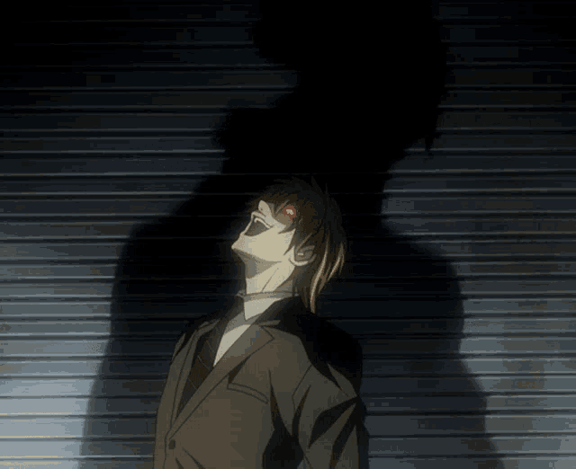 a man in a suit with red eyes is standing in the dark