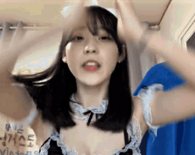 a woman in a maid costume is making a funny face