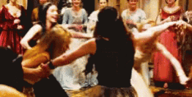 a man and a woman are dancing in a room with a group of women .