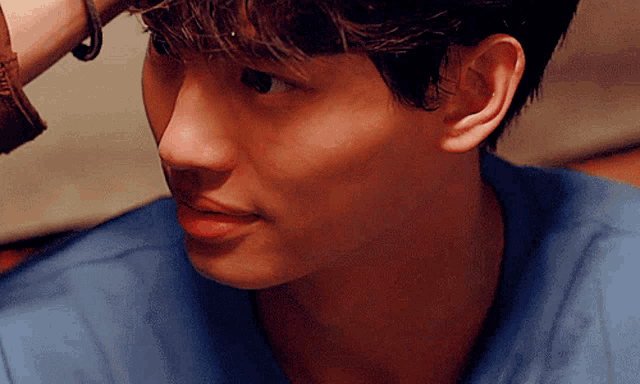 a close up of a man 's face with a blue shirt