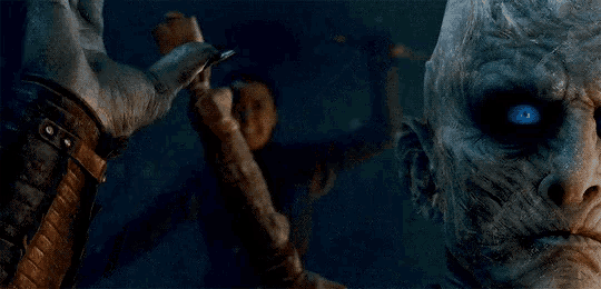 a man with blue eyes is holding a sword in front of a monster
