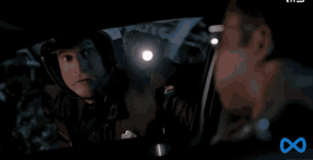 a man wearing a helmet is looking at another man