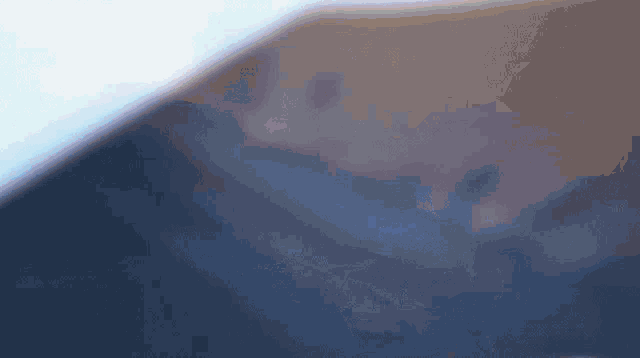 a blurry picture of a person 's face with a blue sky in the background